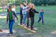 Kids walk together on two wooden boards in the garden