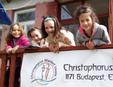 Kids smile at the entrance of the school